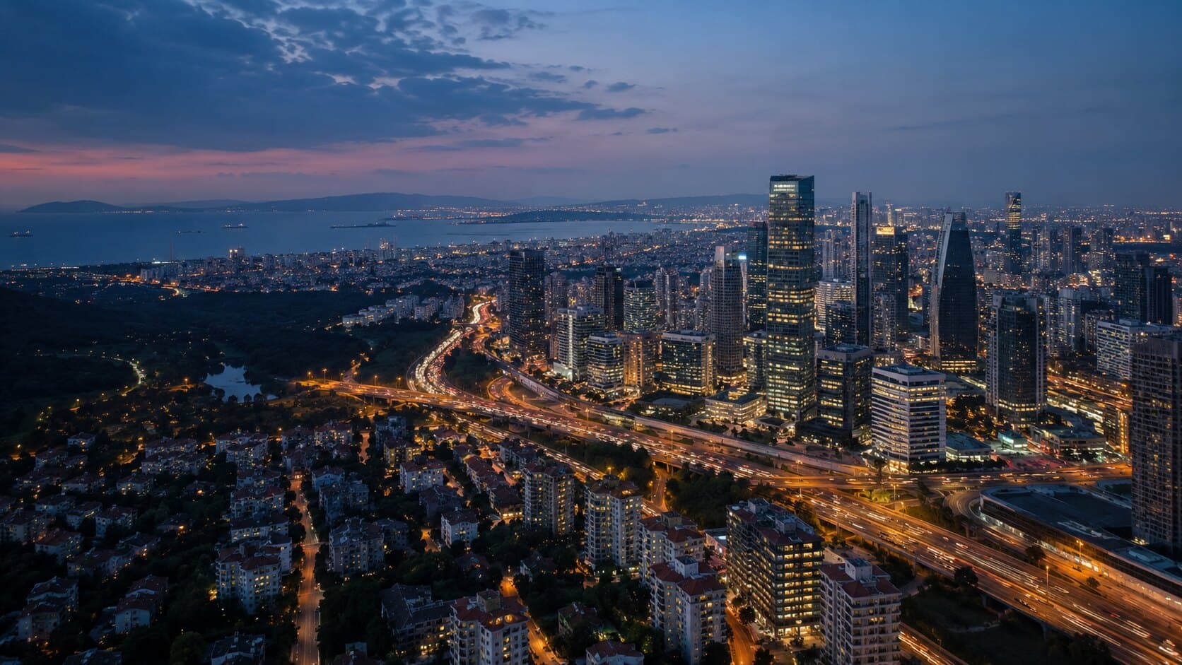Alacakaranlıkta gökdelenleri ve otoyol kavşağıyla şehir manzarası